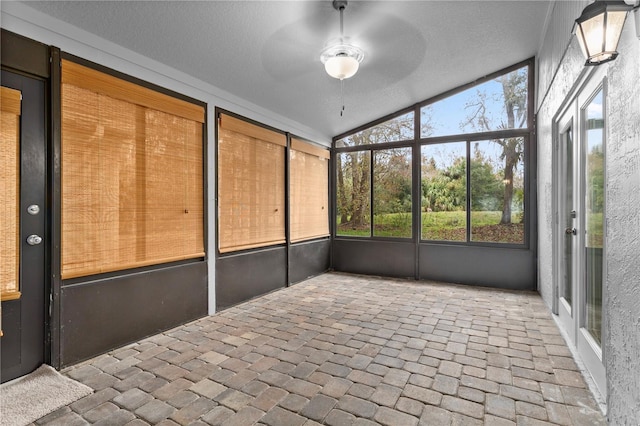 unfurnished sunroom featuring ceiling fan and vaulted ceiling