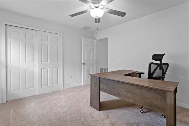 carpeted office space featuring ceiling fan