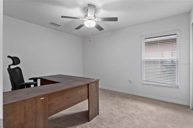 office area featuring a textured ceiling, light colored carpet, and ceiling fan