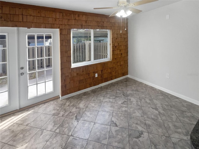 unfurnished room with wood walls and ceiling fan