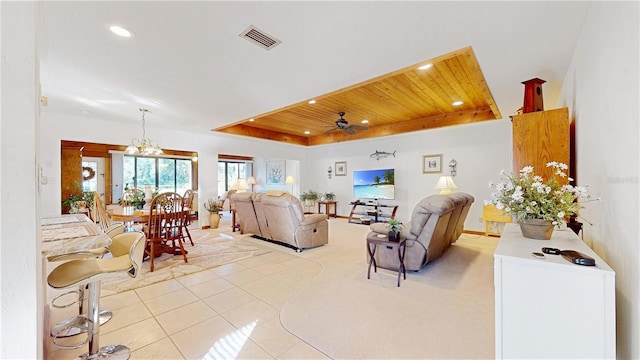 tiled living room featuring a raised ceiling, wood ceiling, and ceiling fan with notable chandelier