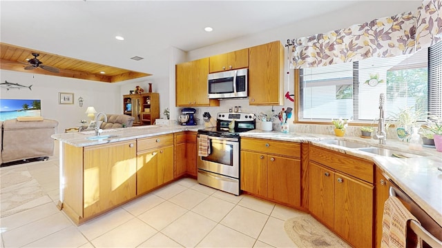 kitchen featuring ceiling fan, appliances with stainless steel finishes, kitchen peninsula, and sink