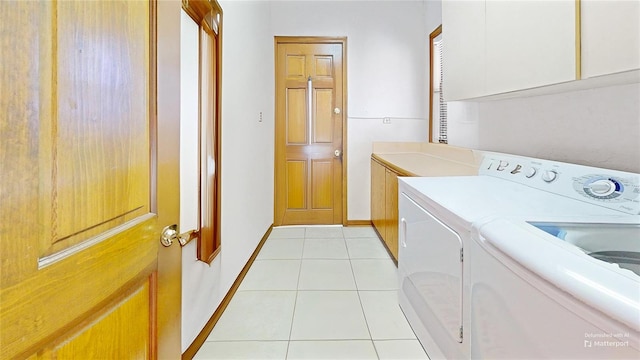 laundry room with cabinets, light tile patterned floors, and washer and clothes dryer