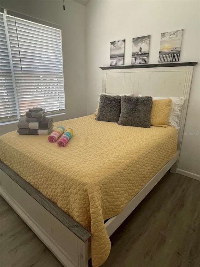 bedroom with dark hardwood / wood-style flooring