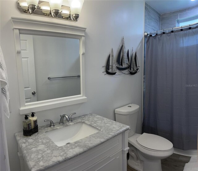 bathroom featuring vanity, curtained shower, and toilet