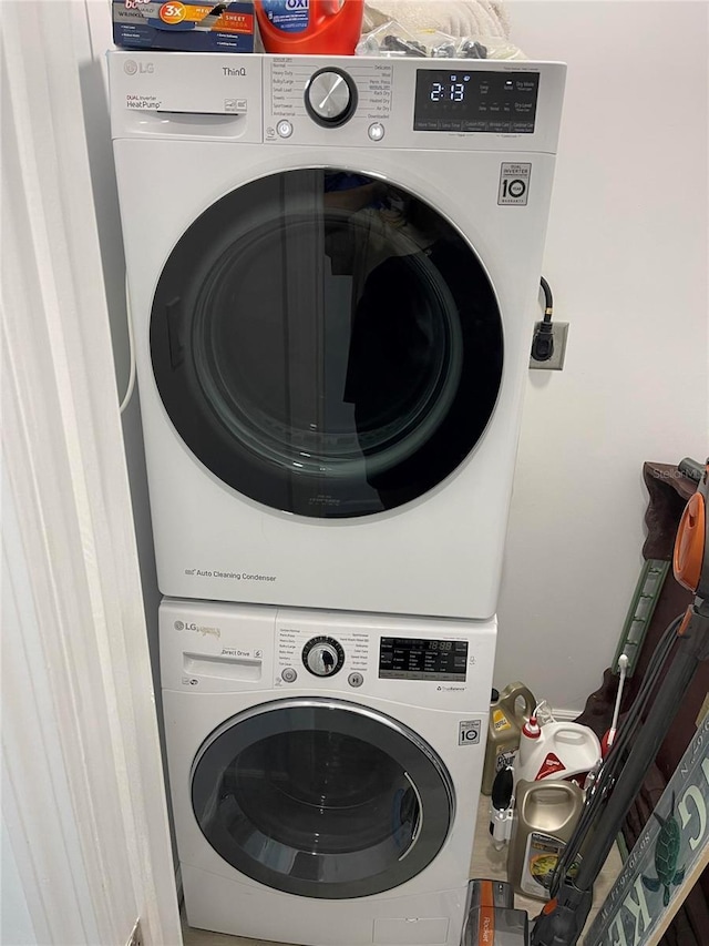 clothes washing area with stacked washer / dryer