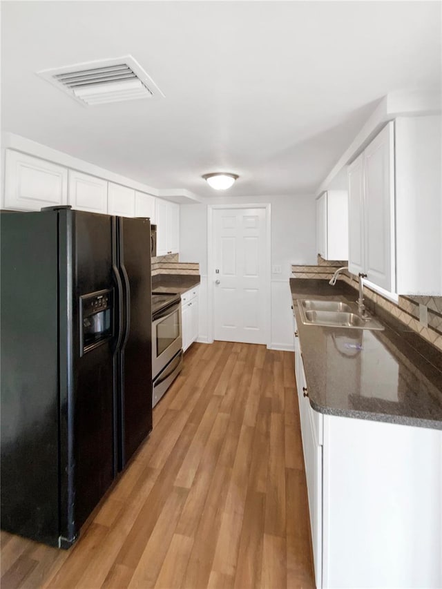 kitchen with white cabinetry, stainless steel electric range oven, black fridge with ice dispenser, and sink