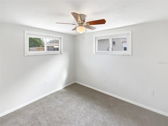 empty room featuring ceiling fan and carpet