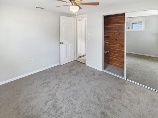 unfurnished bedroom featuring carpet flooring, ceiling fan, and a closet