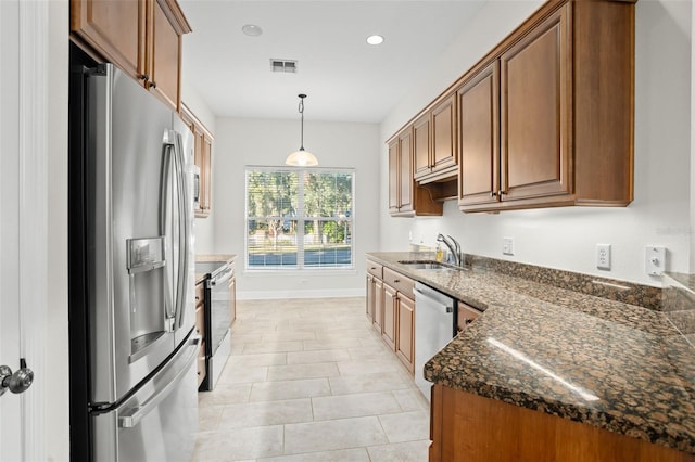 kitchen with stainless steel appliances, sink, light tile patterned floors, decorative light fixtures, and dark stone countertops