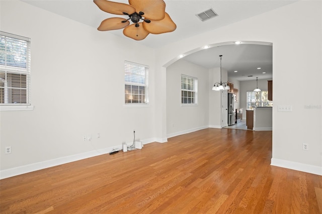 empty room featuring hardwood / wood-style floors and ceiling fan with notable chandelier