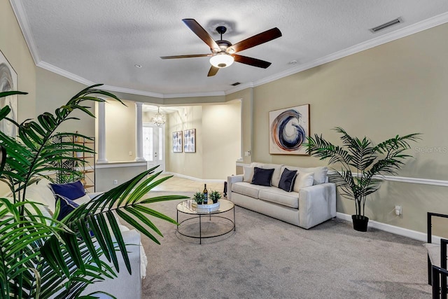 carpeted living room featuring ceiling fan with notable chandelier, ornamental molding, and a textured ceiling