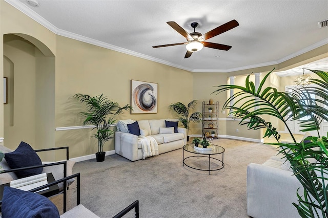 carpeted living room with ceiling fan and ornamental molding