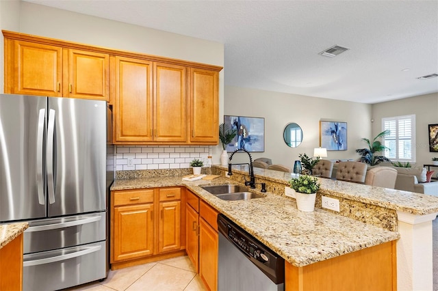 kitchen featuring sink, backsplash, kitchen peninsula, light tile patterned flooring, and appliances with stainless steel finishes