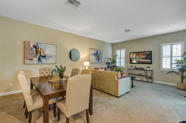 dining area with plenty of natural light and light colored carpet