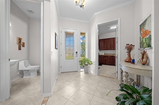 tiled foyer entrance featuring crown molding and a textured ceiling