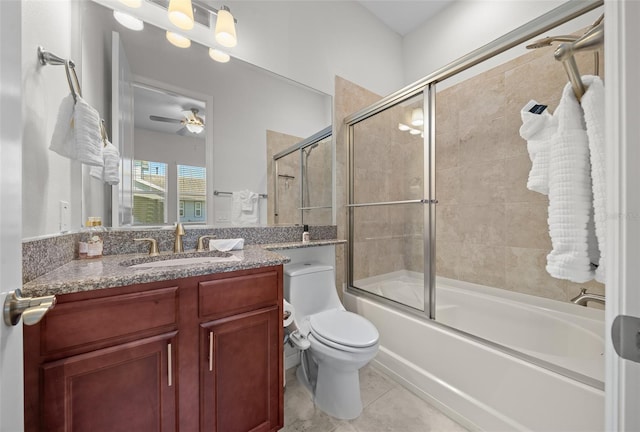 full bathroom with combined bath / shower with glass door, tile patterned floors, vanity, ceiling fan, and toilet