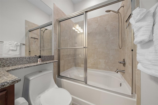 full bathroom with combined bath / shower with glass door, vanity, and toilet