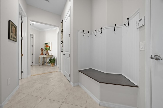 mudroom featuring light tile patterned floors and ornamental molding