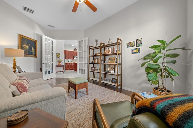 living room featuring ceiling fan, light wood-type flooring, and french doors