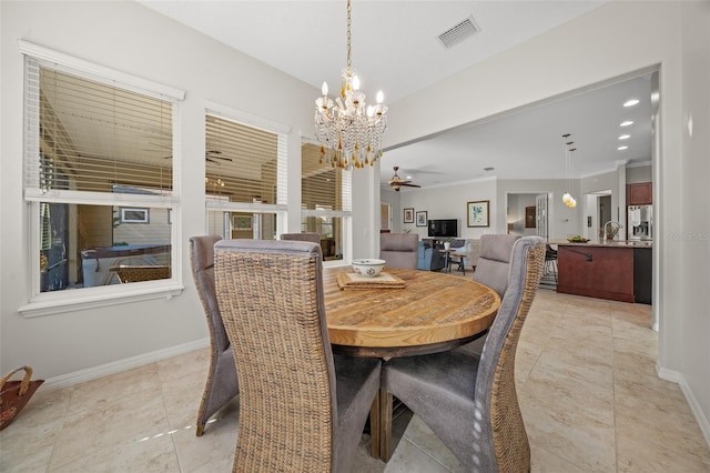 dining area with light tile patterned flooring, ceiling fan with notable chandelier, and ornamental molding