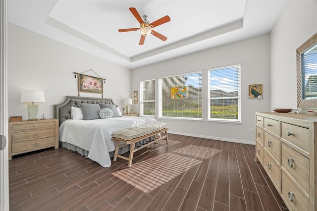 bedroom with a raised ceiling and ceiling fan