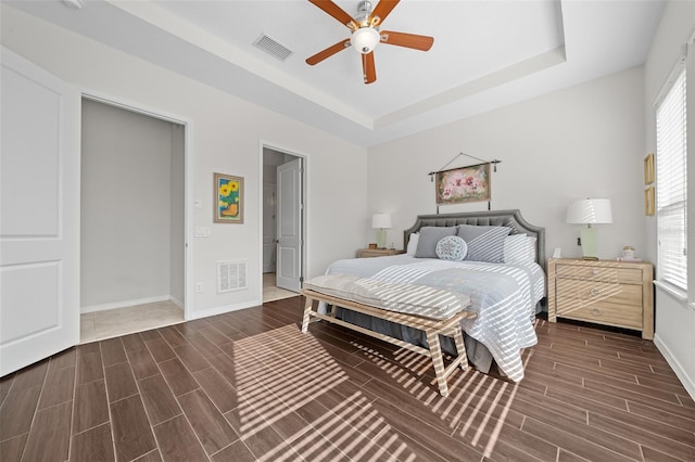 bedroom featuring ceiling fan and a tray ceiling