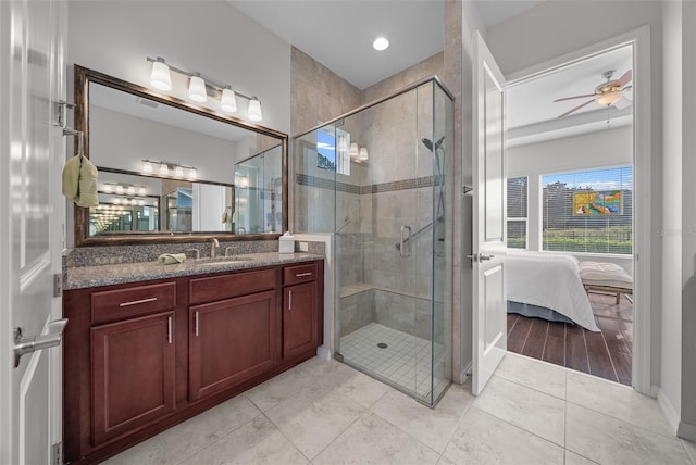 bathroom with tile patterned floors, ceiling fan, a shower with shower door, and vanity