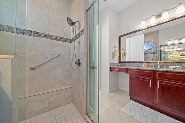 bathroom with tile patterned flooring, vanity, and walk in shower