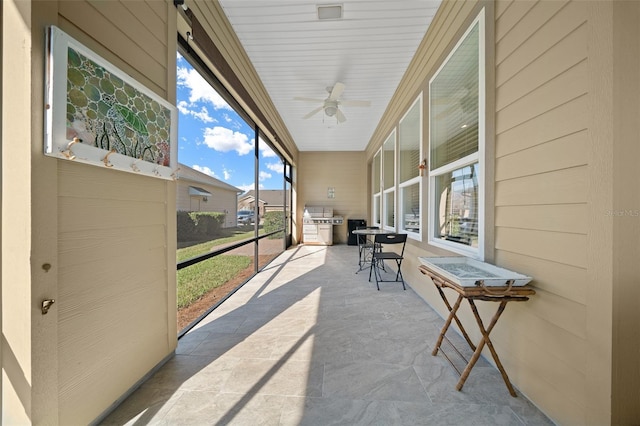 sunroom / solarium featuring ceiling fan