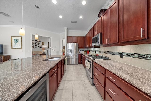 kitchen featuring crown molding, light stone countertops, sink, and appliances with stainless steel finishes