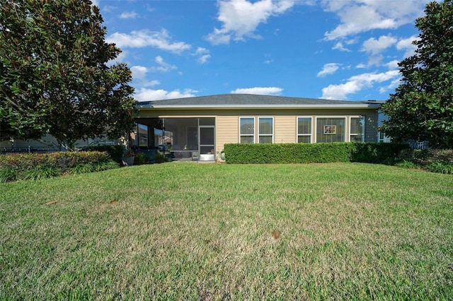 back of house with a lawn and a sunroom