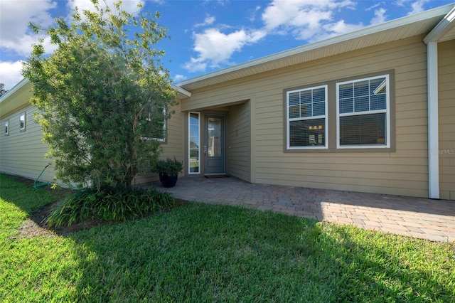 back of house with a yard and a patio