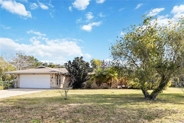 view of property hidden behind natural elements with a garage and a front yard