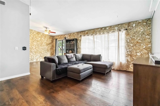 living room featuring dark wood-type flooring and ceiling fan