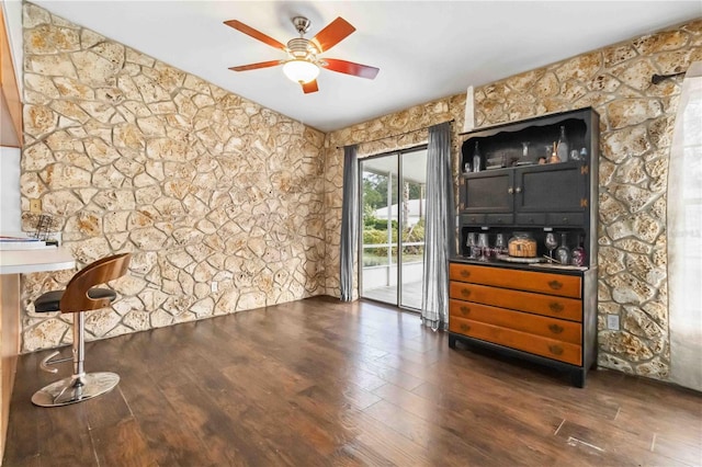 bar with ceiling fan and dark hardwood / wood-style floors