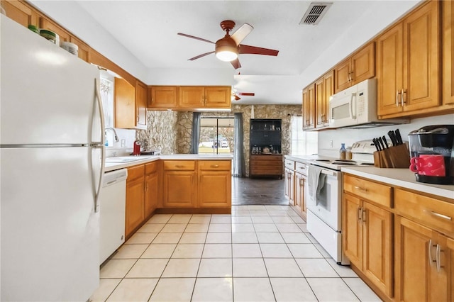 kitchen featuring sink, white appliances, light tile patterned floors, kitchen peninsula, and ceiling fan