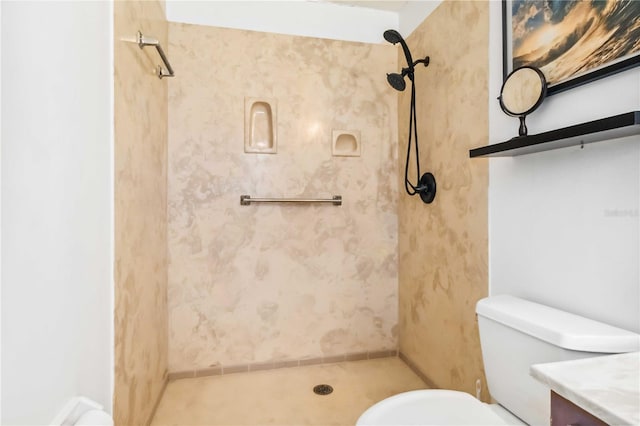 bathroom with vanity, toilet, and tiled shower