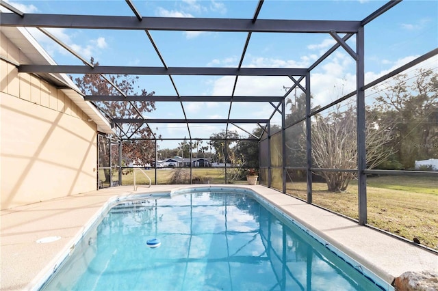 view of swimming pool featuring glass enclosure and a lawn