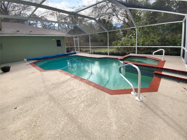 view of pool featuring a lanai, a patio area, and an in ground hot tub