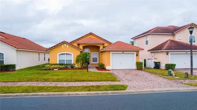 mediterranean / spanish-style home featuring a front yard and a garage