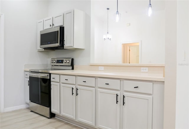 kitchen featuring white cabinets, appliances with stainless steel finishes, light hardwood / wood-style floors, and pendant lighting