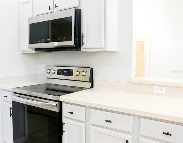 kitchen featuring stainless steel appliances and white cabinets