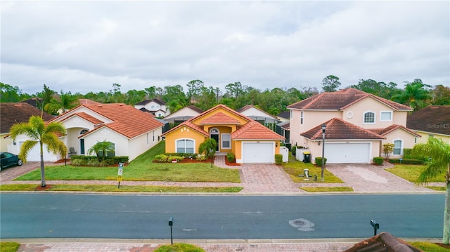 mediterranean / spanish-style house featuring a front yard and a garage