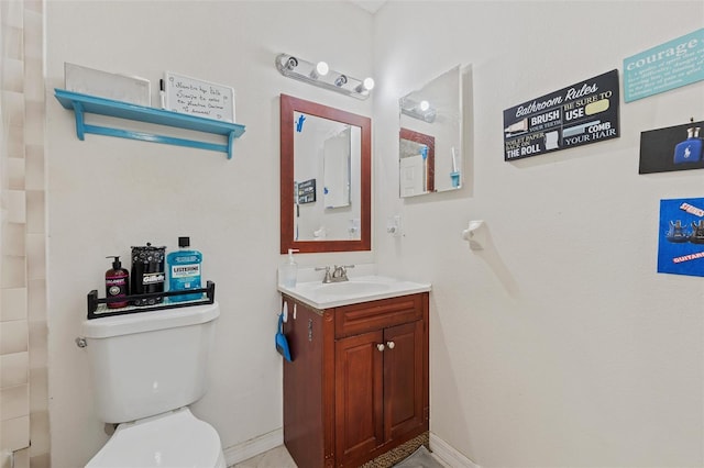 bathroom featuring vanity, toilet, and baseboards