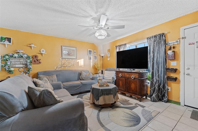 living room featuring light tile patterned flooring, ceiling fan, and a textured ceiling