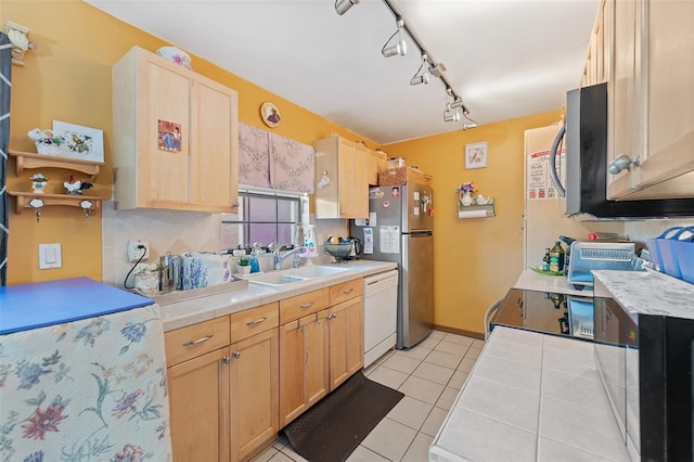 kitchen featuring tile countertops, stainless steel appliances, light brown cabinetry, and a sink