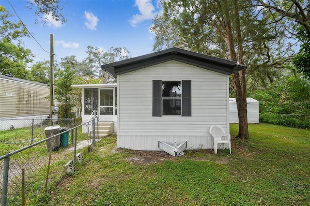 view of side of property with a yard, central AC, and a sunroom