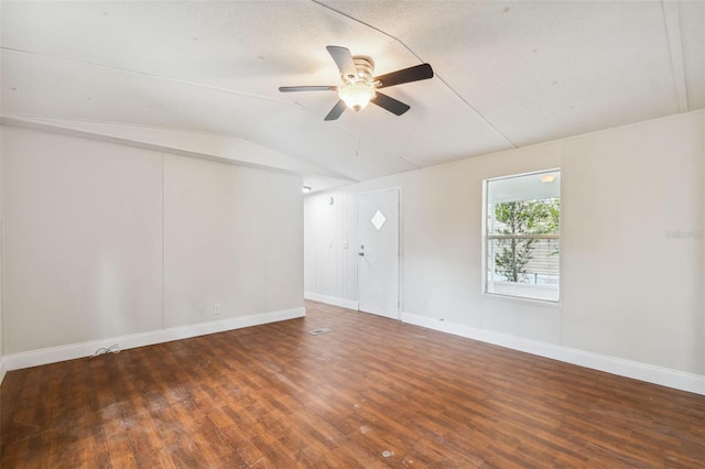 empty room featuring ceiling fan, dark wood-type flooring, and vaulted ceiling