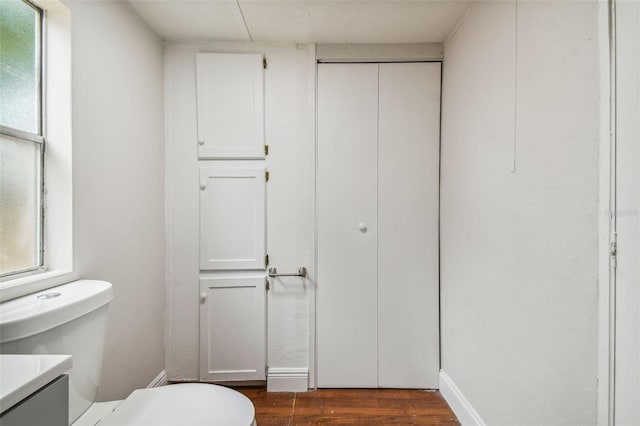 bathroom featuring toilet, vanity, and hardwood / wood-style flooring